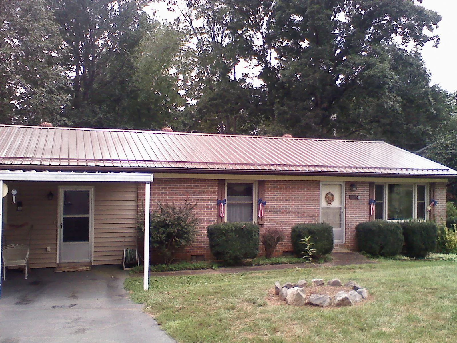 Bronze metal roof and carport on a brick ranch home — Roof Repair work by our crew in Bronx